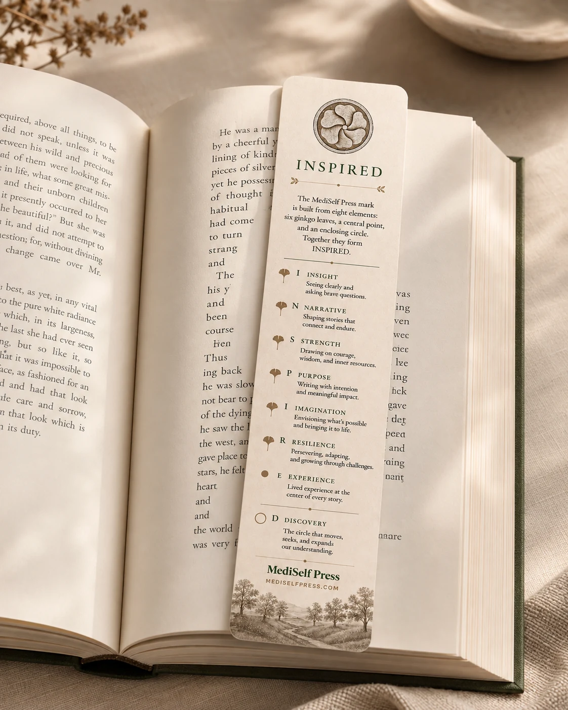 The INSPIRED bookmark resting inside an open book